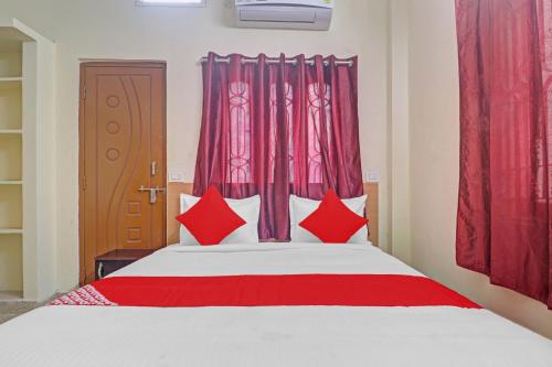 a bedroom with a large bed with red pillows at Hotel O RBS Square Langer Houz in Hyderabad