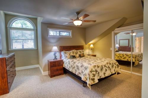 a bedroom with a bed and a ceiling fan at Embrace the Fore Seasons in Pinetop! in Indian Pine