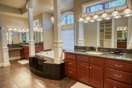 a bathroom with two sinks and a tub and a large mirror at Embrace the Fore Seasons in Pinetop! in Indian Pine