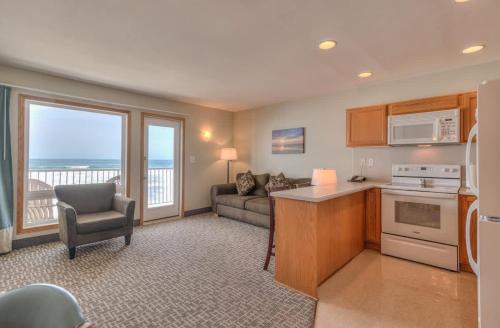 a kitchen with a living room with a couch and a table at Oceanfront One Bedroom Suite Stunning Views & King Bed in Lincoln City
