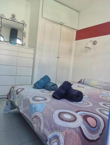 a bedroom with a bed with blue pillows on it at Maspalomas Casa La Loba in Maspalomas