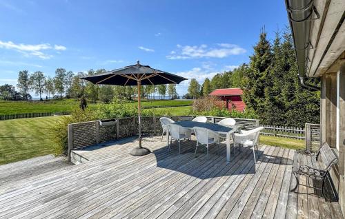 a wooden deck with a table and an umbrella at Amazing Home In Motala With Wifi in Motala