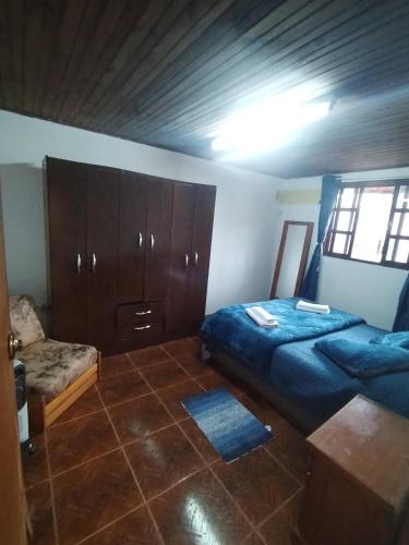 Un dormitorio con una cama y un armario y una ventana. en Hospedaje Cuaro, en Rivera