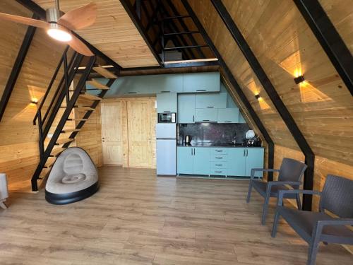 a large room with a staircase and a kitchen at Alisa's cottage in Racha ალისას კოტეჯი რაჭაში in Kharistʼvala