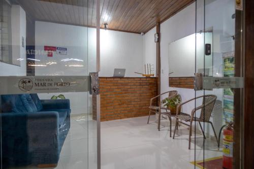 a glass door in a room with a table and chairs at Pousada Mar de Porto in Porto Seguro