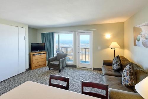 a living room with a couch and a television at Oceanfront Suite - Beach Access - Heated Pool and Hot Tub in Lincoln City