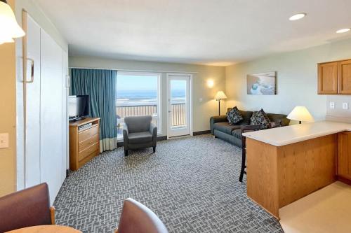 a living room with a couch and a television at Oceanfront Suite - Beach Access - Heated Pool and Hot Tub in Lincoln City