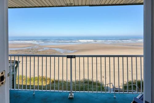 a view of the beach from the balcony of a house at Oceanfront Suite - Beach Access - Heated Pool and Hot Tub in Lincoln City