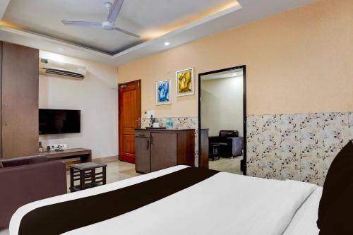 a bedroom with a bed and a living room at Super Collection O FRI Dehradun in Dehradun