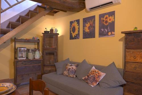 a living room with a couch and a staircase at Il Respiro del Borgo in Civitella Del Lago