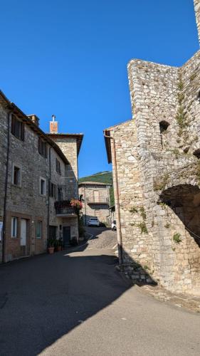 an alley between two buildings with a stone wall at Il Respiro del Borgo in Civitella Del Lago
