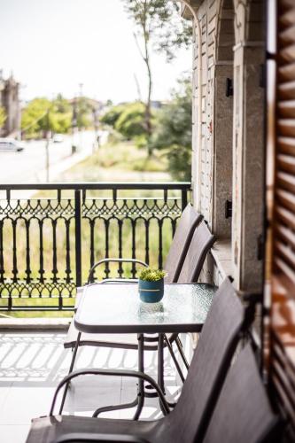 a table and chairs on a balcony with a table and a plant at ANGO First Floor Apartment in Stavros
