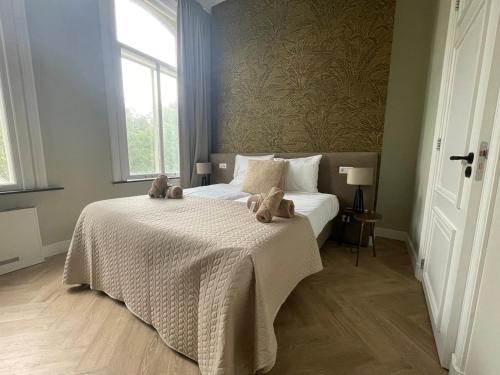 a bedroom with a bed with two teddy bears on it at Luxe Suite - New Bed - Wifi- Safe City Center in Tilburg