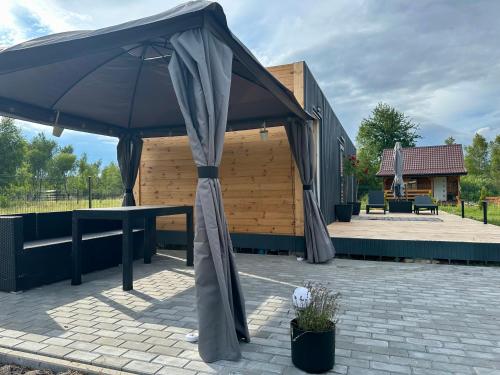 a large umbrella sitting on a brick patio at Mazurski domek przy jeziorze Roś 2 in Szczechy Małe