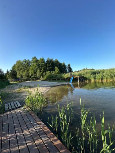 a view of a river with a wooden walkway at Mazurski domek przy jeziorze Roś 2 in Szczechy Małe