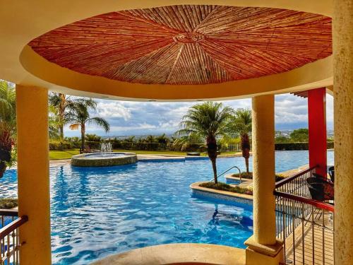 a swimming pool with an umbrella in a resort at Brand New lake view Penthouse with office space in Santa Ana