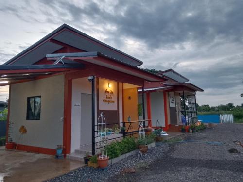 a small house with a red and white at บ้านพักริมน้ำหนองคาย in Ban Na Kai