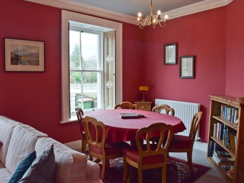 a red dining room with a table and chairs at Shorley Lodge in Keswick