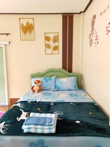 a bedroom with a bed with a teddy bear on it at บ้านพักริมน้ำหนองคาย in Ban Na Kai