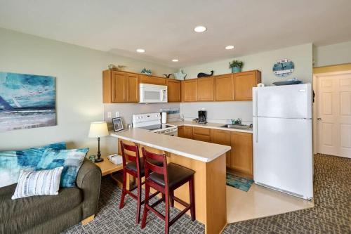 a kitchen with a couch and a white refrigerator at Oceanfront Suite - Sleeps 6 - Beach Access & Full Kitchen in Lincoln City