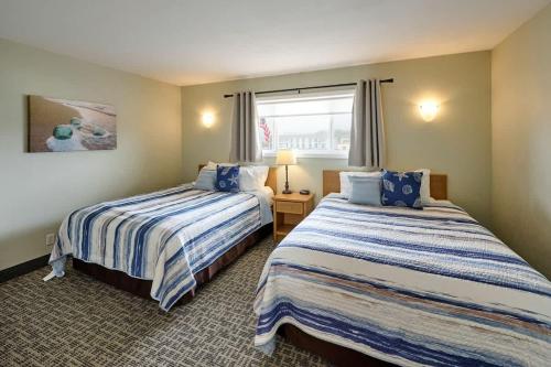 a hotel room with two beds and a window at Oceanfront Suite - Sleeps 6 - Beach Access & Full Kitchen in Lincoln City