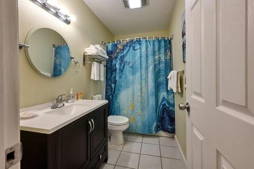 a bathroom with a sink and a blue shower curtain at Oceanfront Suite - Sleeps 6 - Beach Access & Full Kitchen in Lincoln City