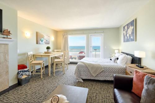 a bedroom with a bed and a living room with a table at Amazing Ocean View Suite - Sleeps Six - Pool Access & Hot Tub in Lincoln City