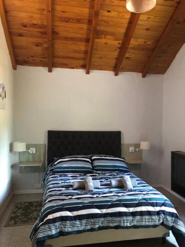 a bed with two pillows on it in a bedroom at Tu Casa en la Naturaleza in San Carlos de Bariloche