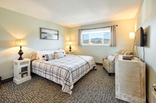 a bedroom with a bed and a chair and a window at Amazing Ocean View Suite - Sleeps Six - Pool Access & Hot Tub in Lincoln City