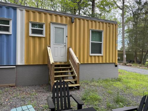 a tiny house with a porch and a door at Camptel Poconos in Albrightsville