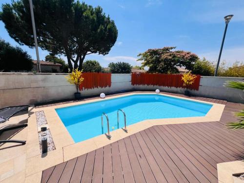 - une piscine sur une terrasse en bois à côté d'une clôture dans l'établissement VILLA PARADIS piscine privee sans vis à vis et plage, à Vendres