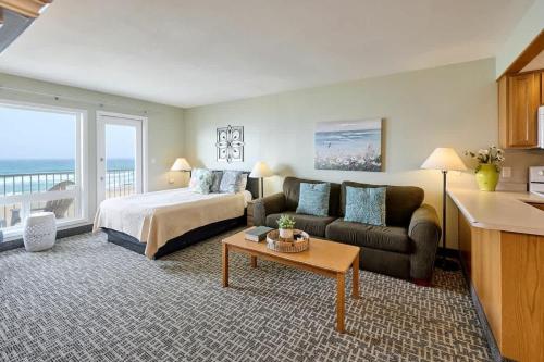 a hotel room with a bed and a couch at Fireplace Suite With King Bed Full Kitchen Ocean Views - Heated Indoor Pool and Hot Tub in Lincoln City
