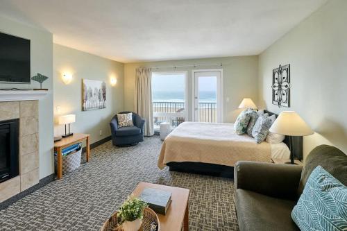 a hotel room with a bed and a fireplace at Fireplace Suite With King Bed Full Kitchen Ocean Views - Heated Indoor Pool and Hot Tub in Lincoln City