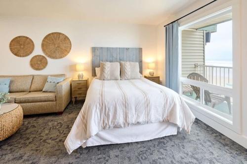 a bedroom with a bed and a couch and a window at Deluxe Suite for 6 King Bed & Ocean Views Pool and Hot Tub in Lincoln City