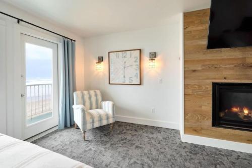 a bedroom with a fireplace and a chair and a window at Deluxe Suite for 6 King Bed & Ocean Views Pool and Hot Tub in Lincoln City