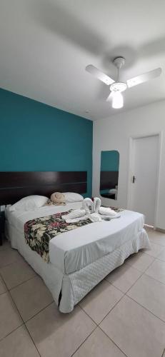 a large bed in a bedroom with a blue wall at Hotel do Sol Executive in São Sebastião