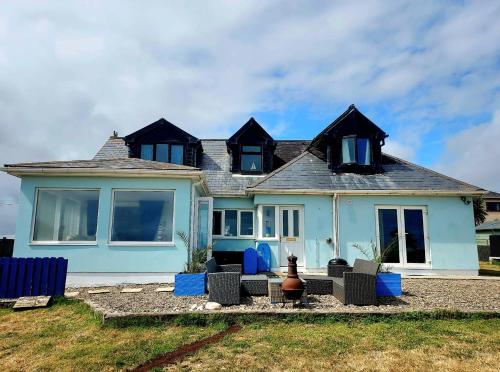 a blue house with blue chairs in front of it at Seaside Chill in Carrick