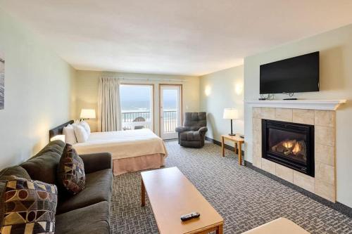 a hotel room with a bed and a fireplace at Fireplace Suite With King Bed and Full Kitchen - Pool and Hot Tub Access in Lincoln City