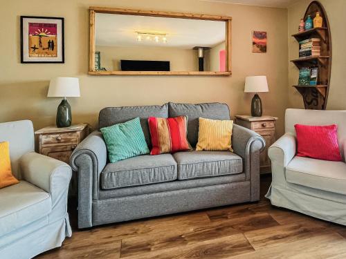 a living room with a couch and two chairs at Kippy Cottage in Porthtowan