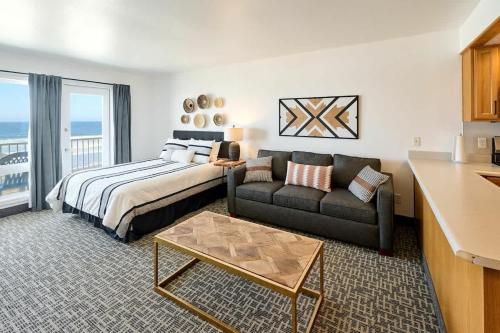 a bedroom with a bed and a couch and a table at Oceanfront Suite - King Bed - Heated Indoor Pool & Hot Tub in Lincoln City