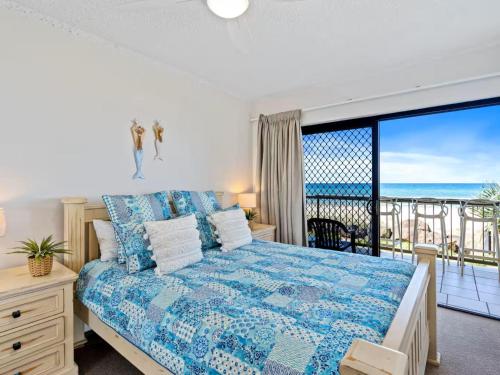 a bedroom with a bed and a view of the ocean at Palm Breeze - Hosted by Burleigh Letting in Gold Coast