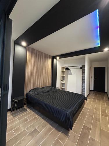 a bedroom with a large black bed in a room at Maison SPA 2025 in Mont-près-Chambord