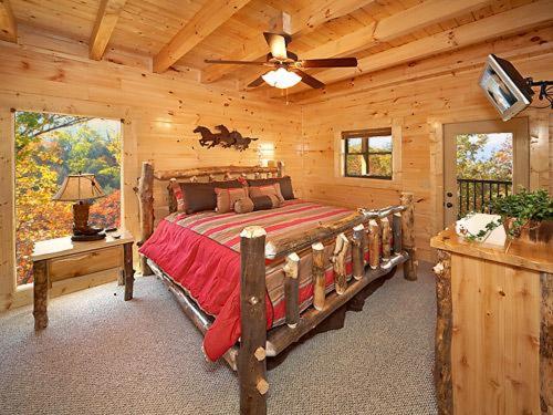 ein Schlafzimmer mit einem großen Bett in einem Blockhaus in der Unterkunft Firefly Lodge Holiday home in Gatlinburg