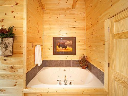 ein Badezimmer mit einer Badewanne in einer Holzhütte in der Unterkunft Firefly Lodge Holiday home in Gatlinburg