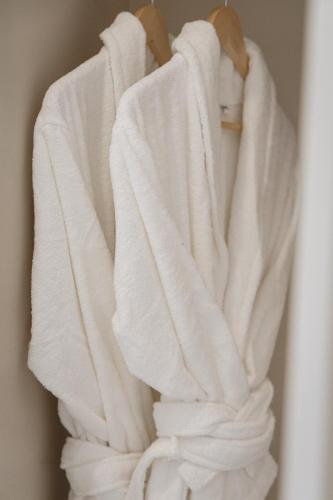 a pile of white towels hanging on a rack at Vogel Rooms Tvrđa Osijek in Osijek