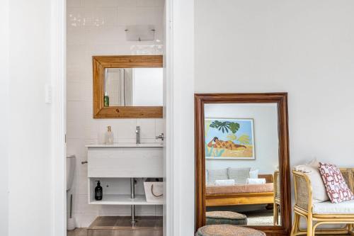 a bathroom with a mirror and a sink at Byron Beachside 5 in Byron Bay
