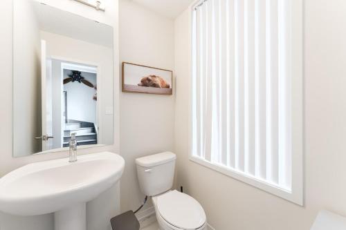 a white bathroom with a sink and a toilet at Luxury Townhouse in Vaughan in Vaughan