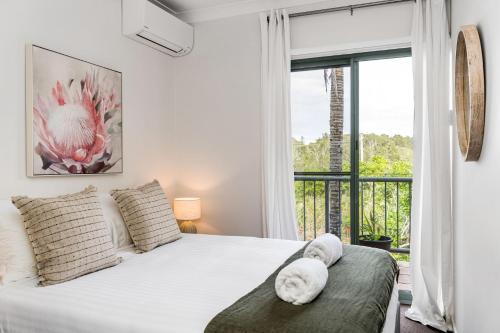 a bedroom with a bed and a large window at Byron Beachside 5 in Byron Bay