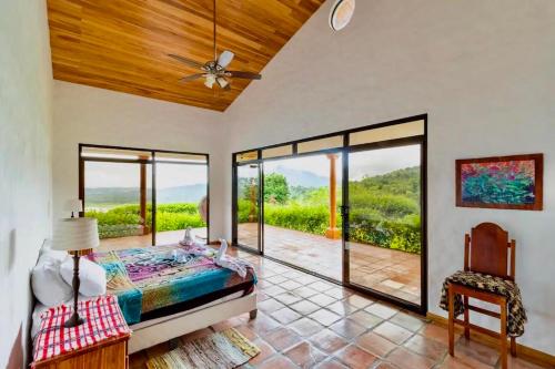 una camera da letto con un letto e porte scorrevoli in vetro di Serenity House Panoramic Views And Swimming Pool, a El Castillo de la Fortuna