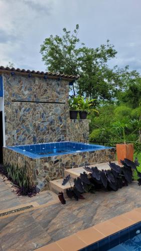 a stone building with a swimming pool in a yard at Alojamiento Reserva Natural La Maria in Armenia